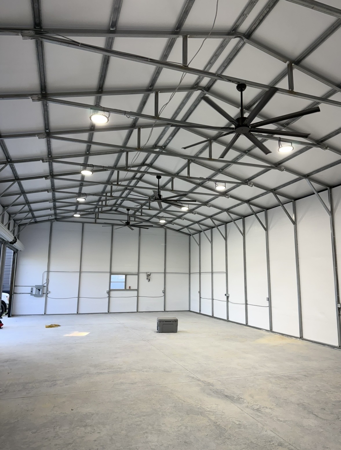 Metal building interior with LED high bay lights and large ceiling fans